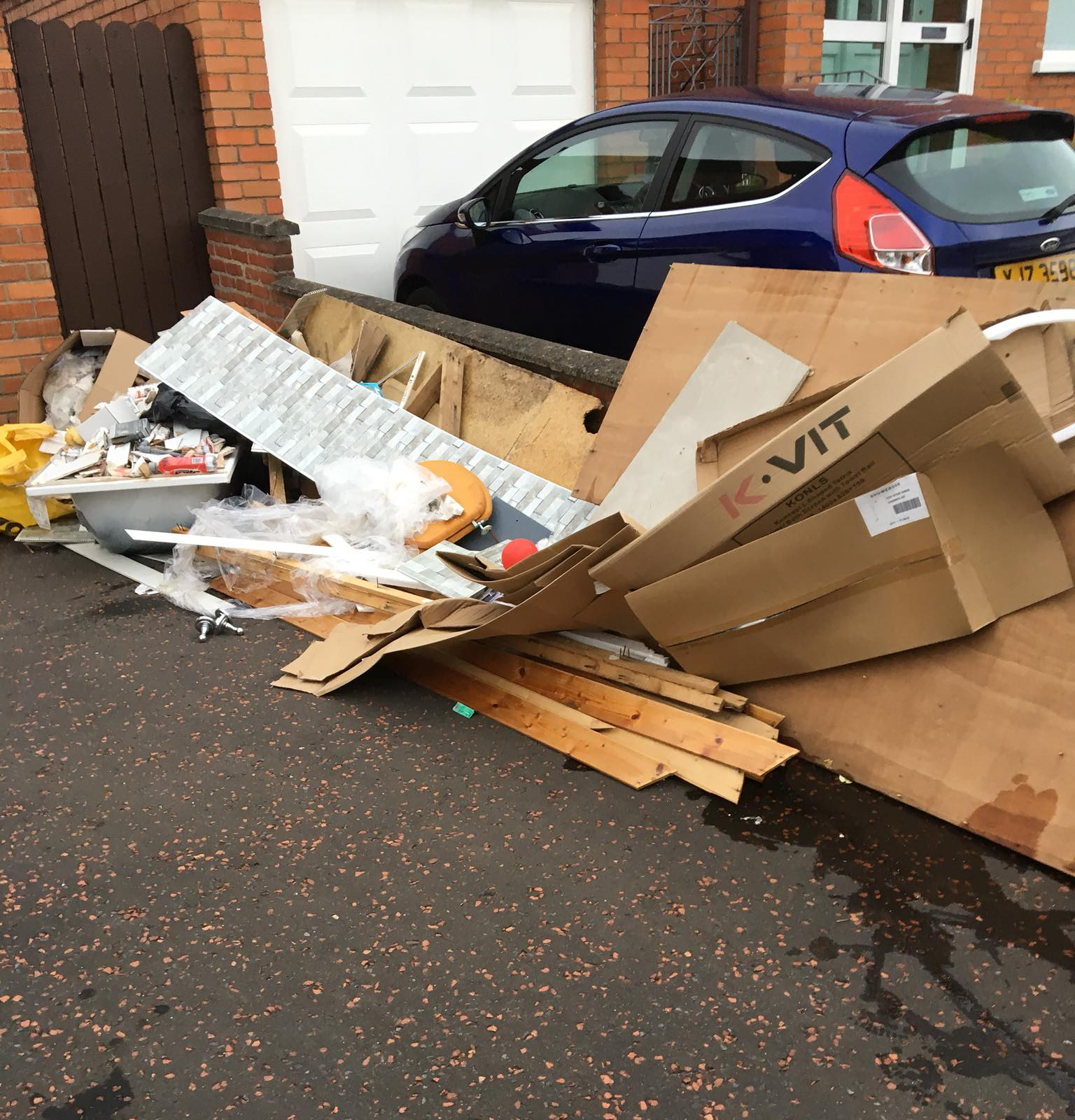 Tarmac driveway blocked by scrap wood and rubbish